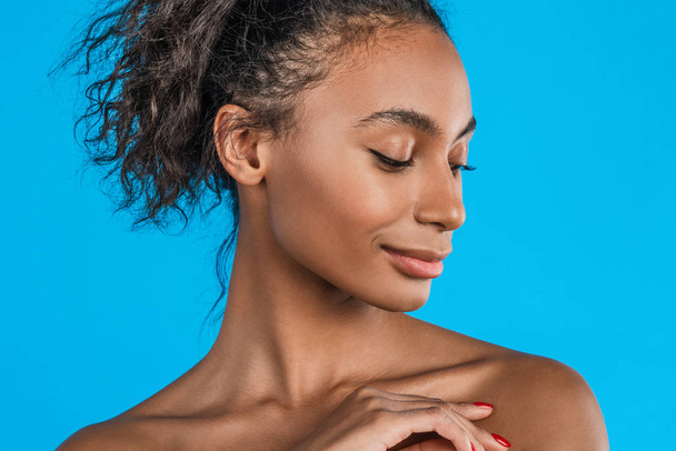 Beauty close up profile portrait of beautiful mixed race african american woman isolated on blue background - Foto, Imagem