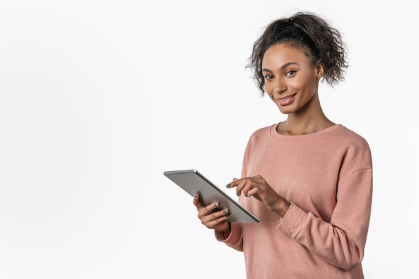 Jovem mulher africana de pé e usando tablet computador isolado sobre fundo branco
 - Foto, Imagem