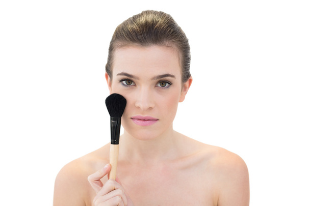 Serious model holding a blush brush - Foto, imagen