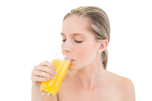 Meditative fresh blonde woman enjoying orange juice - Photo, image