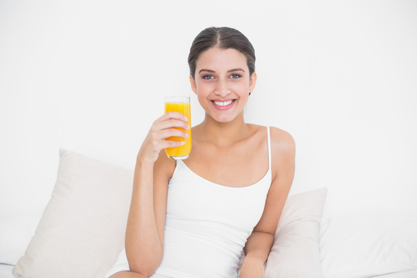 Model in white pajamas holding a glass of orange juice - Photo, image