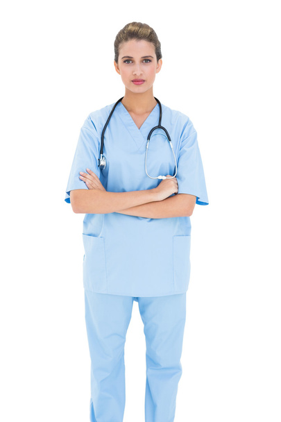 Serious nurse in blue scrubs posing with arms folded - Фото, зображення