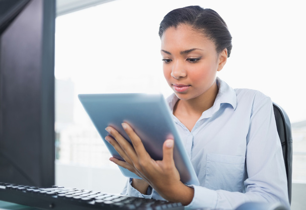 Concentrated young businesswoman using a tablet pc - Foto, Imagen