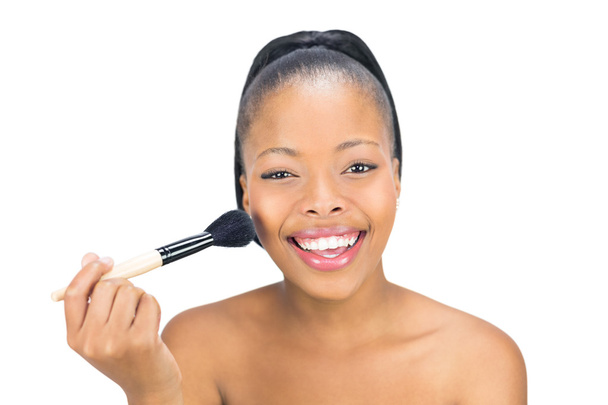 Attractive woman applying powder to face with brush - Foto, afbeelding