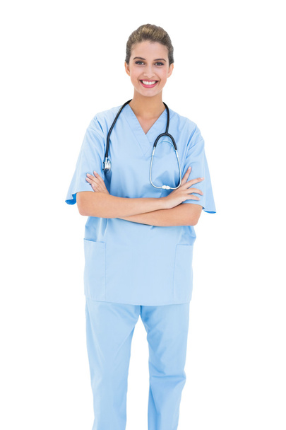 Smiling nurse in blue scrubs posing with arms crossed - Foto, Bild