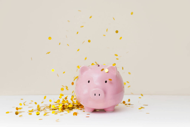 A lot of gold coins falling into a piggy bank - Foto, immagini