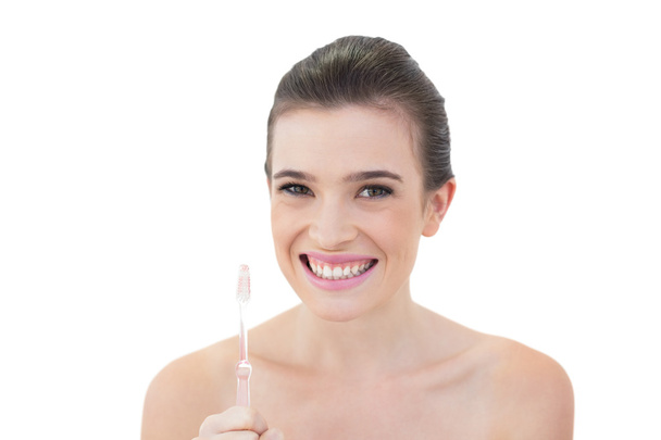 Delighted model holding a toothbrush - Photo, image