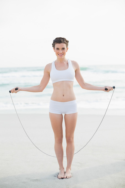 Content slim model playing with a skipping rope - Foto, Imagen