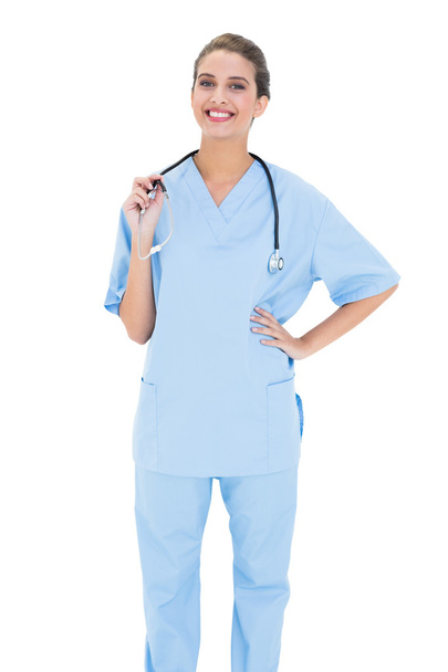 Happy nurse in blue scrubs looking at camera - Фото, изображение