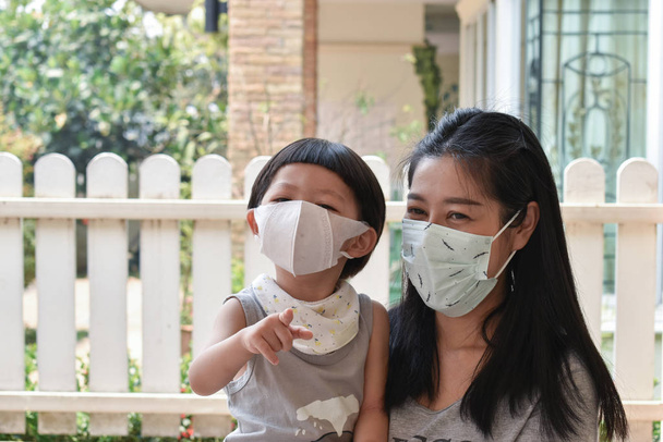 Mutter und Kind mit Mundschutz schützen Luftverschmutzung mit PM 2,5 - Foto, Bild