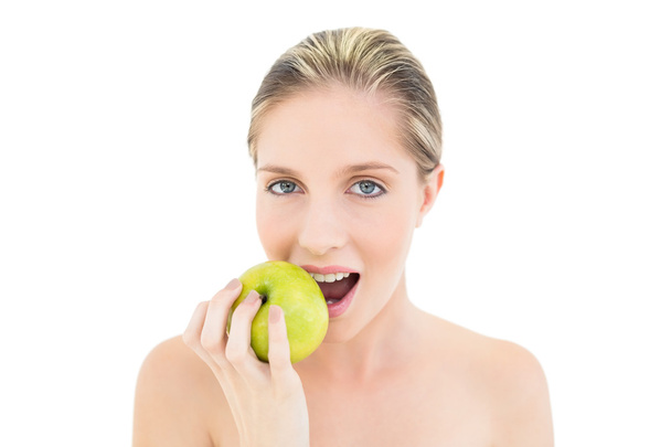 Natural fresh blonde woman eating a green apple - Fotó, kép