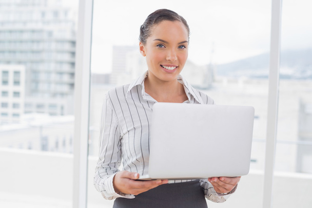Standing businesswoman using a laptop - Zdjęcie, obraz
