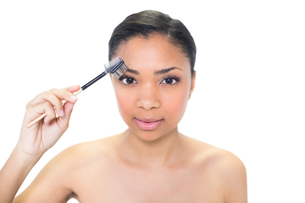 Attractive young model brushing her eyebrows - Photo, image