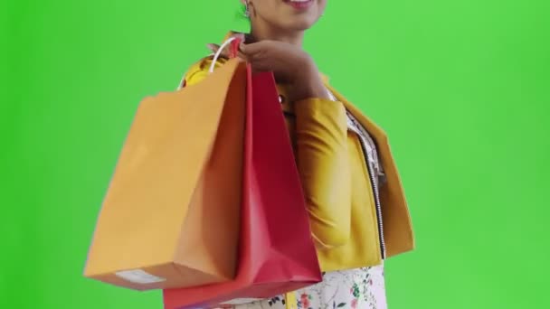 Portrait of african american woman with shopping bags and money fan on green Background in Studio. Yellow jacket - Filmagem, Vídeo