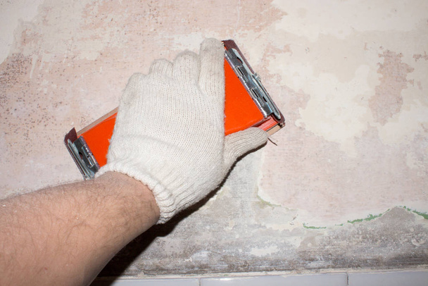 Lijar las paredes con papel de lija. Limpiar las paredes para pintar
. - Foto, Imagen