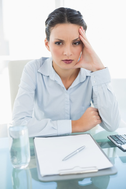 Bored stylish brunette businesswoman holding her head and looking away - Photo, image