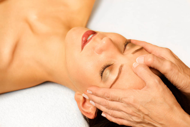 young woman gets facial massage - Foto, Imagen