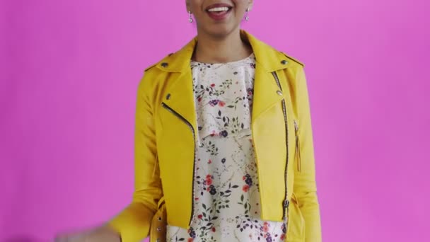 Satisfied african american woman with money is showing thumb up on pink background Yellow jacket - Footage, Video