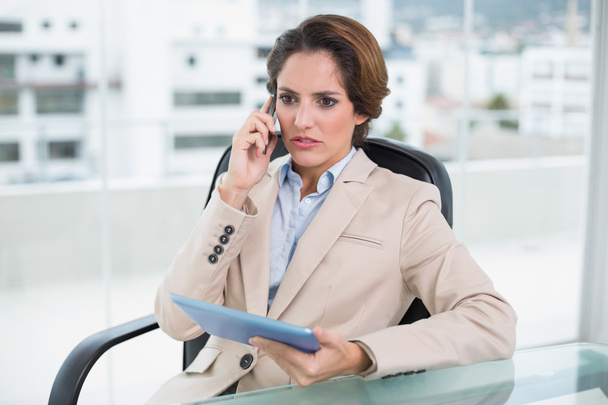 Frowning businesswoman on a call holding tablet - Foto, Imagen