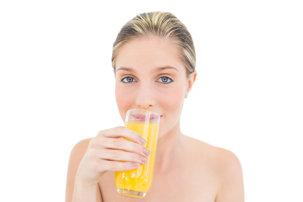 Natural fresh blonde woman drinking orange juice - 写真・画像