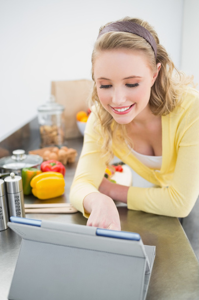 Smiling cute blonde looking at tablet - Photo, image