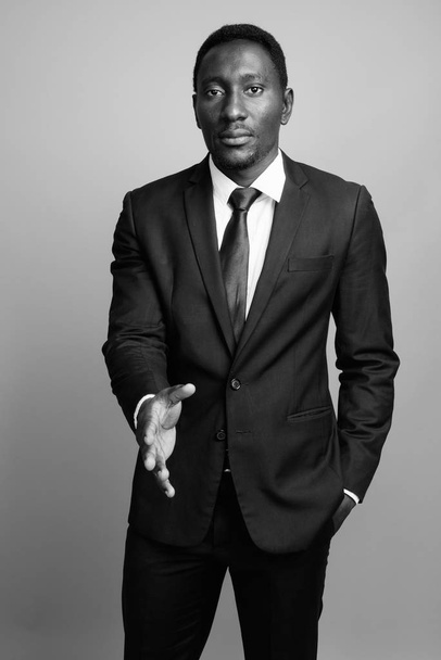 Jeune homme d'affaires africain beau sur fond gris - Photo, image