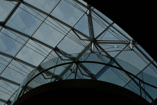 Toiture en verre avec armure métallique avec ciel bleu en arrière-plan dans les couleurs noir et bleu
 - Photo, image
