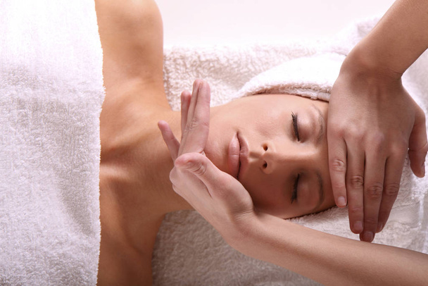 young woman receiving massage at spa center - Fotó, kép