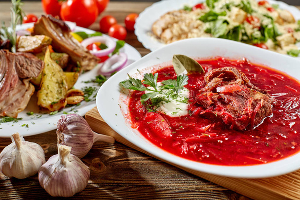 木製の背景に赤いビーツ野菜スープ ボルシチ。ウクライナとロシアの国民食。クローズ アップ. - 写真・画像