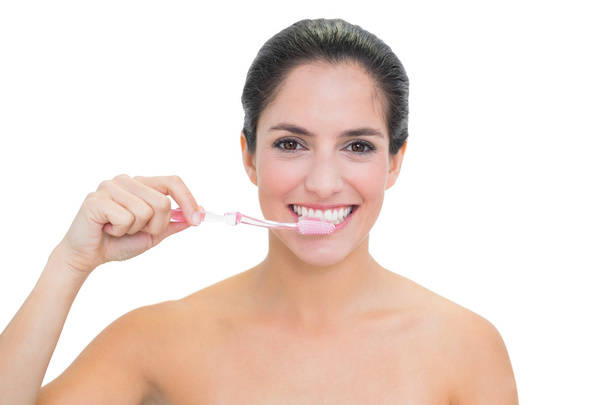 Smiling bare brunette using toothbrush - Foto, Imagem