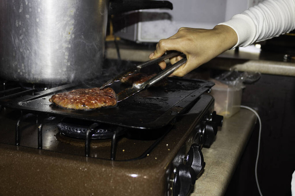 Frau bereitet im eigenen Lebensmittelgeschäft einen Hamburger zu - Foto, Bild