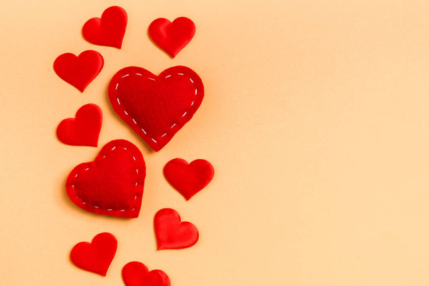 Верхній вид червоних текстильних сердець на кольоровому тлі з копіювальним простором. Романтична концепція. День Святого Валентина - Фото, зображення