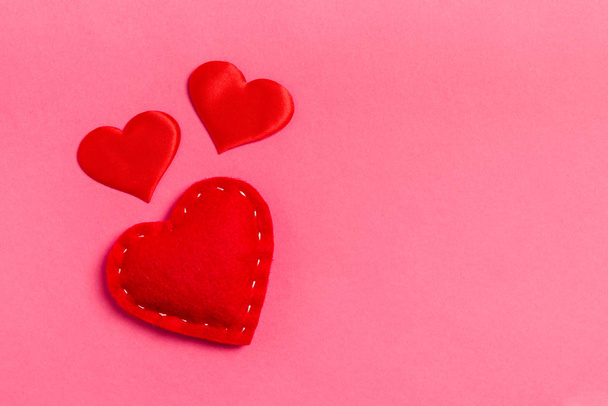 Vista superior de corações têxteis vermelhos sobre fundo colorido com espaço de cópia. Conceito romântico. Dia de São Valentim
 - Foto, Imagem