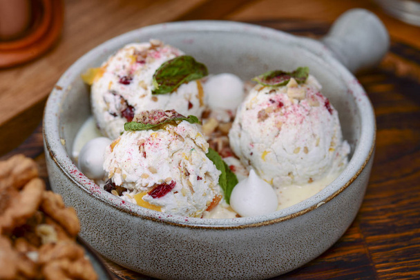 Traditional Georgian ice cream dessert. Nakhini salted caramel ice cream with candied fruits and nuts served in a bowl - Photo, Image