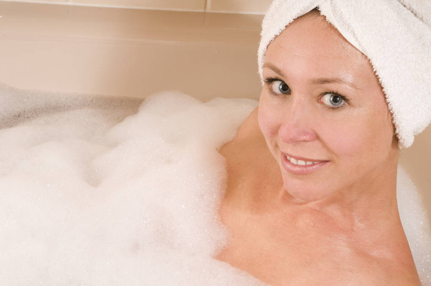 woman in bathtub with towel in the head - Foto, imagen