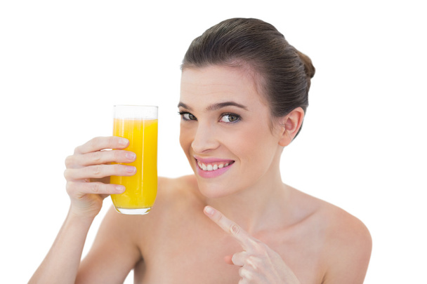 Amused model showing her glass of orange juice - Photo, Image