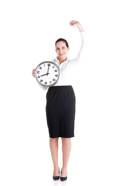 Happy young business woman holding office clock - Zdjęcie, obraz