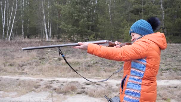 Hermosa mujer dispara un rifle de caza en la naturaleza
 - Metraje, vídeo