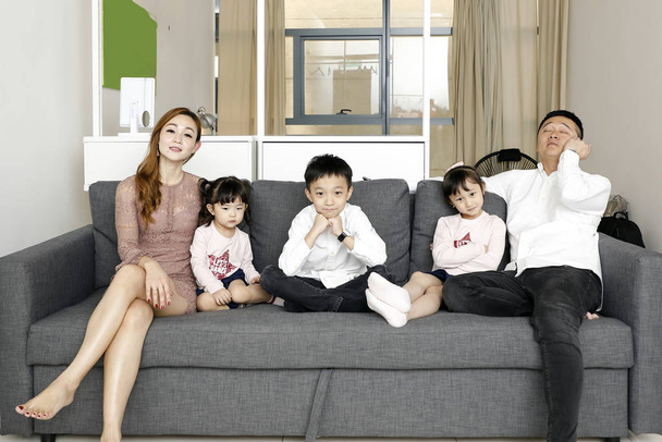 Rodzice Dziecko Rodzina ojciec matka córka syn siedzieć na kanapie watc - Zdjęcie, obraz
