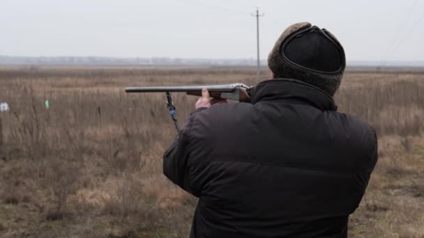 Cazador macho maduro dispara una escopeta en la naturaleza
 - Metraje, vídeo