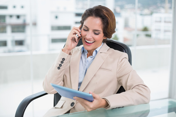 Businesswoman using smartphone and holding tablet - Foto, Bild
