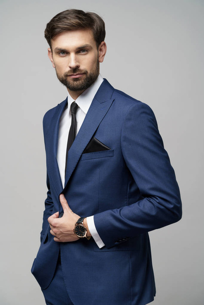 studio photo of young handsome businessman wearing suit - Foto, Imagen