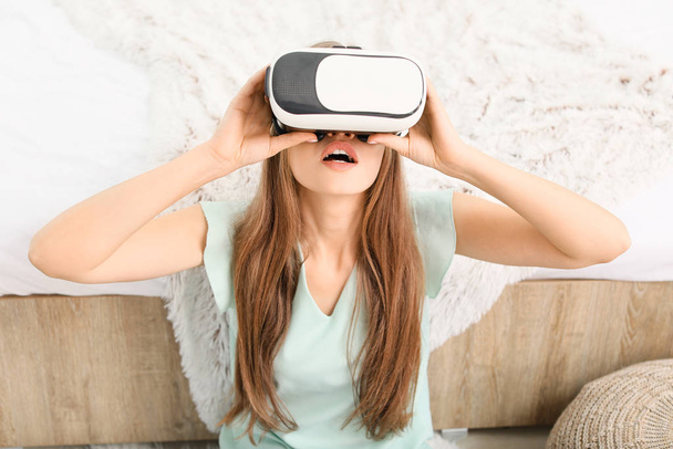 Mujer joven con gafas de realidad virtual en casa - Foto, Imagen