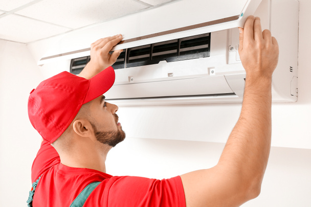 Male technician repairing air conditioner indoors - Fotoğraf, Görsel