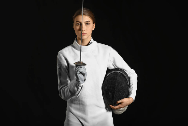 Young female fencer on dark background - Foto, Imagem
