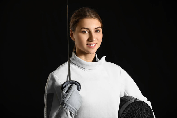 Young female fencer on dark background - 写真・画像