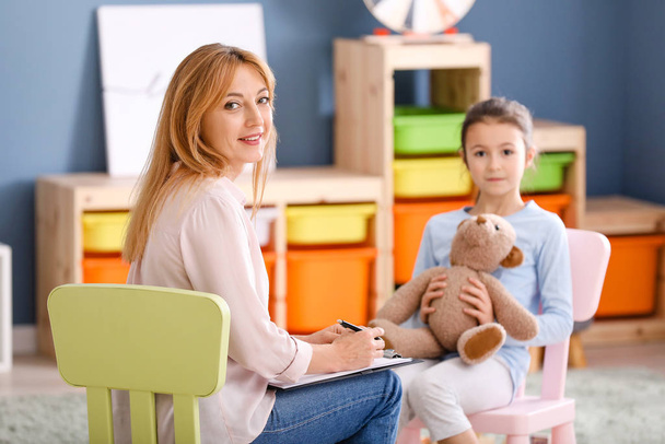 Psicólogo trabajando con una niña pequeña en el interior
 - Foto, imagen