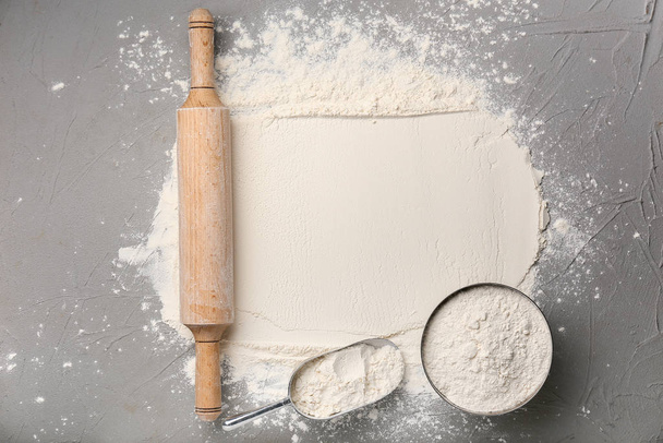 Flour with rolling pin on grey background - Foto, Bild