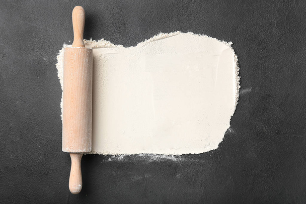 Flour with rolling pin on dark background - Foto, afbeelding
