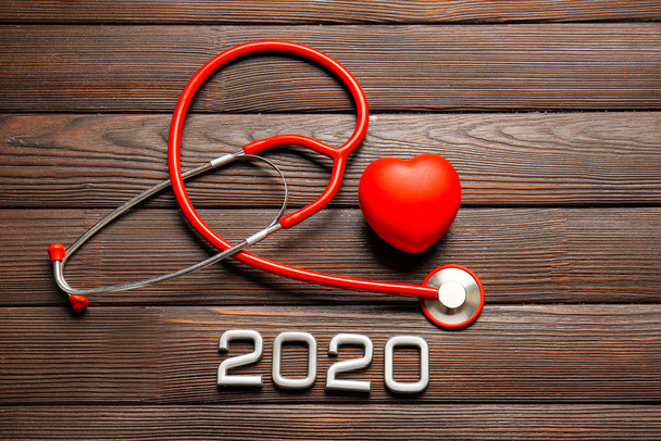 Stetoscopio, cuore e figura 2020 su sfondo di legno
 - Foto, immagini